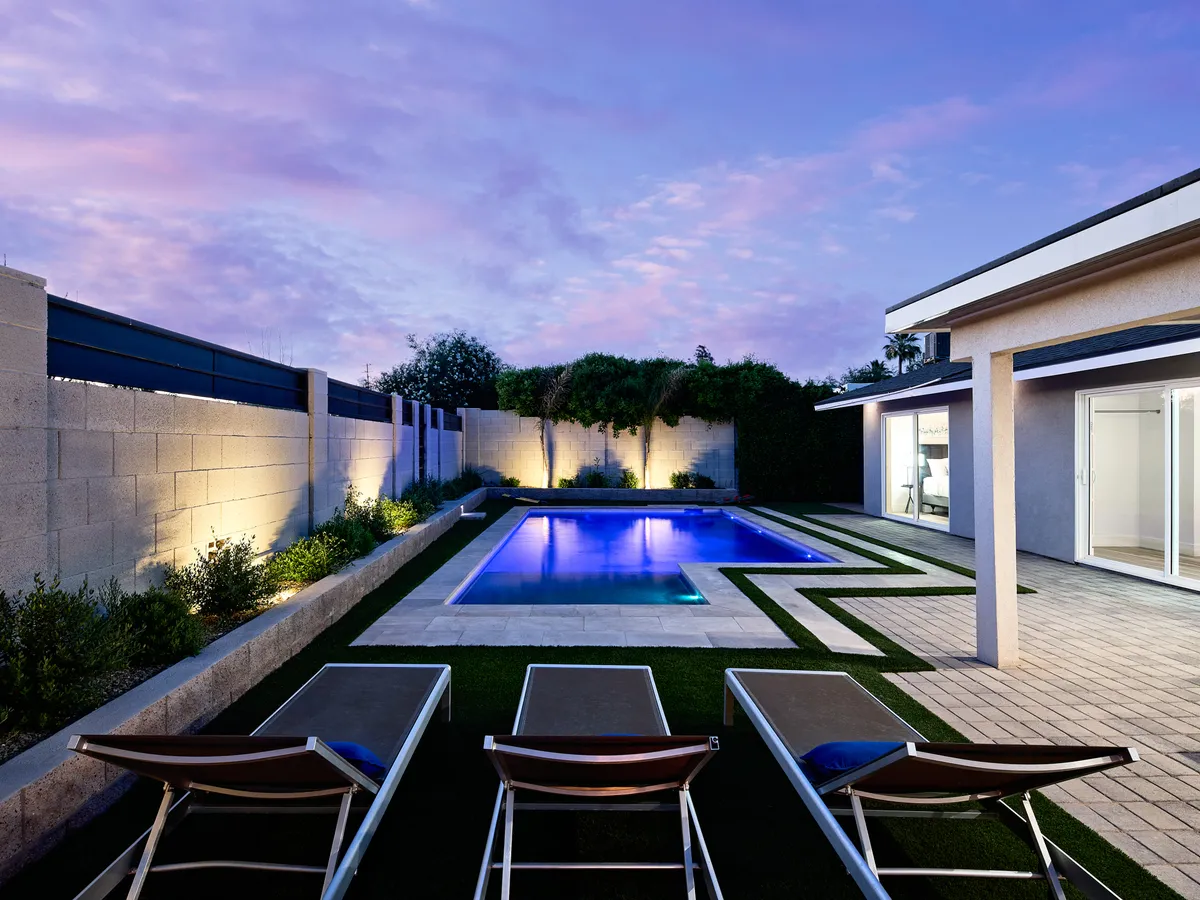 A relaxing pool area with sun loungers and beautifully landscaped gardens. The inviting pool is surrounded by lush planting, creating a peaceful environment for sunbathing or evening swims.