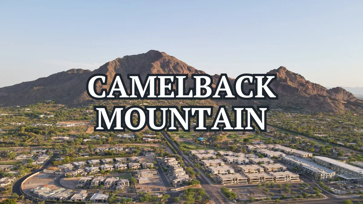 This image showcases Camelback Mountain rising in the background, with residential areas and green spaces in the foreground. The early morning light suggests an ideal setting for sunrise hikes and outdoor exploration.